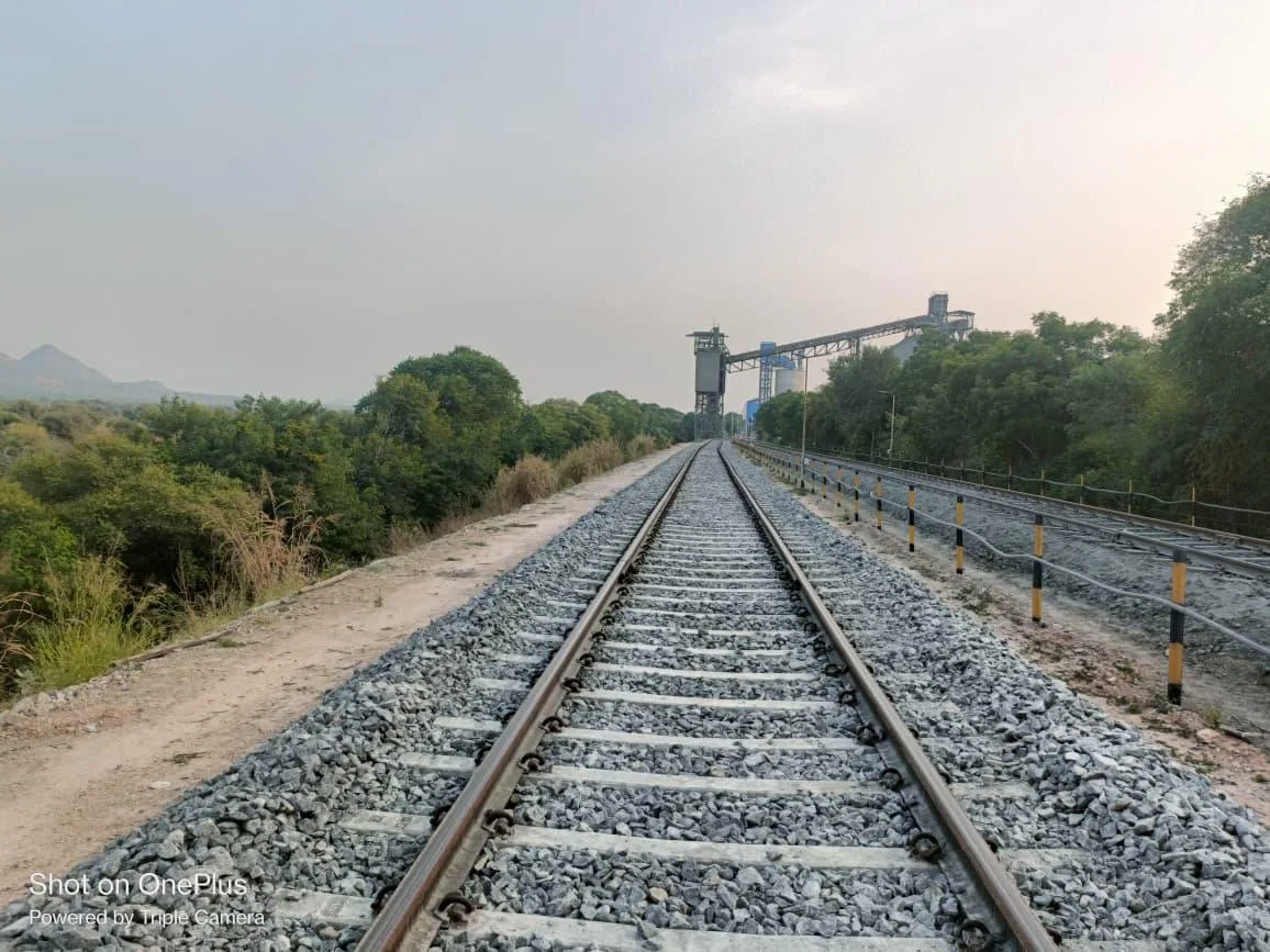 Siding track leading up to a conveyor and silo structure at dusk